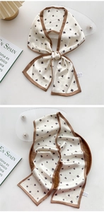 Detail of cream floral silk scarf with dark brown edges and delicate small flower patterns