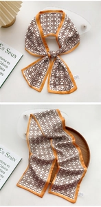 Detail of elegant orange and white silk scarf featuring a brown chain link geometric pattern