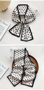 Detail of black and white silk twilly scarf with letter C pattern and elegant bow knot