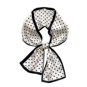 Elegant long skinny scarf with classic black and white polka dot pattern on white background