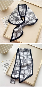 Dettaglio di un elegante foulard in seta geometrico bianco e nero annodato