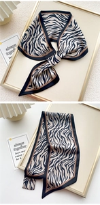 Dettaglio di un foulard in seta twilly zebrato con bordo nero e nodo elegante
