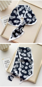 Dettaglio di un elegante foulard di seta bianco e nero con motivi floreali e cuori