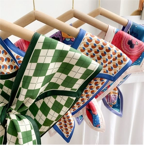 Detail of assorted patterns on satin silk scarves hanging on a wooden hanger