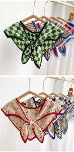 Close-up of assorted printed silk scarves featuring checkered and floral patterns