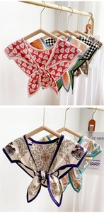 Detail of silk-like neck scarves with diverse heart, checkered, and baroque patterns