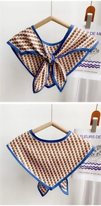 Detail of a silk scarf collar with blue and beige geometric patterns and bow tie design