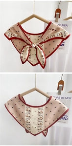 Close-up of cream triangular scarf with red trim and polka dot bunny pattern