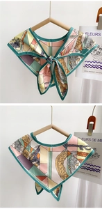 Close-up of decorative collar with geometric floral prints and tied bow on wood hanger