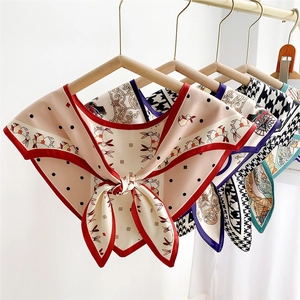 Silk-like triangle neck scarves with diverse patterns on hangers against white background