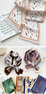 Detail of assorted narrow silk scarves featuring floral, bird, and marble prints