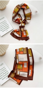 Detail of a narrow silk scarf featuring geometric patterns in orange and brown tones