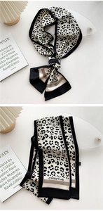 Close-up of leopard print skinny silk scarf with elegant knot and text detail