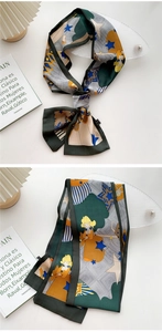 Detail of a dark green silk scarf tied in a bow showing cartoon and geometric patterns
