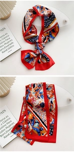 Detail of printed silk scarf with tropical leaves pattern and red hand-rolled edges