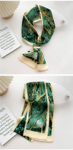 Detail of thin long silk scarf with green marble print and creamy white borders
