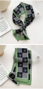 Detail of floral rose pattern on a long silk scarf with green edges and houndstooth design