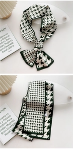 Detail of dark green houndstooth narrow silk scarf with elegant stitching and smooth texture