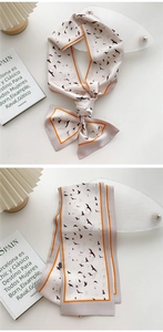 Detailed view of long twilly silk scarf featuring artistic bird prints and contrast borders