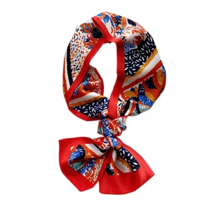 Colorful abstract floral silk scarf with red border in a stylish knotted display