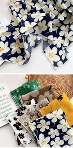 Gros plan de foulards légers en coton à fleurs avec une finition de bordure cousue