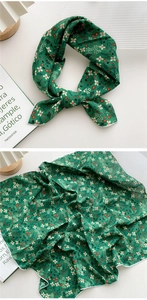 Détail du foulard floral en coton et lin vert foncé avec des bords ourlés blancs élégants