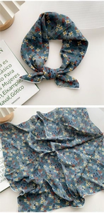 Détail d'un foulard en soie bleu marine à fleurs avec finition bord roulé blanc épuré