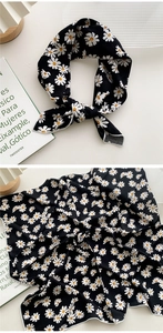 Détail du motif marguerite sur foulard en soie noire avec coutures de bordure blanches