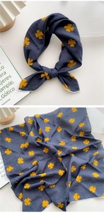 Détail du foulard en coton-lin bleu marine avec imprimé trèfle jaune et bords cousus