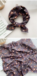 Détail d'un foulard en coton violet foncé avec motif floral vintage et texture douce