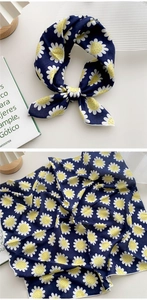Détail d'un foulard bleu marine à motif marguerites avec coutures blanches délicates sur les bords