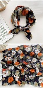 Détail d'un foulard carré bleu marine à imprimé fleuri noué et présenté à plat