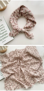 Détails du foulard en coton et lin à fleurs montrant le style noué et la texture
