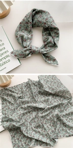Détail du motif floral et des coutures fines sur le foulard en soie vert sauge