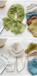 Detail of multi-color long scarves with contrast wavy embroidery and soft fabric texture