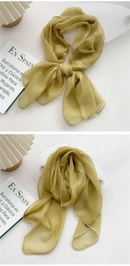 Detail of thin yellow long scarf featuring fine white zigzag hem and translucent texture