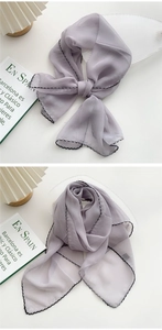 Detail of lavender silk scarf with black wavy edge showing soft texture and drape