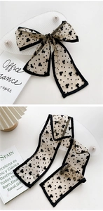 Detail of elegant black clover flocked tulle scarf tied in a bow with contrast edges