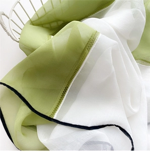 Detail of thin chiffon scarf showing fine stitching and green white color block contrast