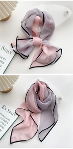 Close-up of pink and grey chiffon scarf featuring black contrast edges and a soft texture