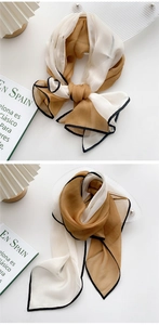 Detail of two-tone beige and caramel long scarf with elegant black piping