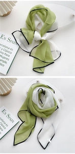 Detail of avocado green and white chiffon scarf with delicate black stitched edges