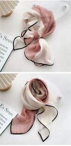 Detail of pink and beige long silk scarf tied in a knot showing smooth texture
