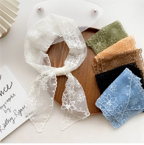 Detail of colorful floral lace neck scarves with embroidery on a wooden display