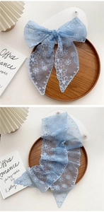 Detail of light blue lace skinny scarf with white floral embroidery and wavy edges