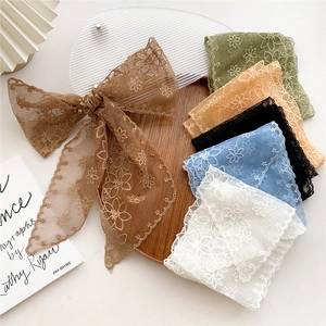 Elegant floral lace skinny scarf assortment with embroidered mesh on a rustic wooden tray