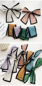 Detail view of colorful polka dot silk scarves showing smooth texture and edge stitching