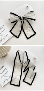 Detailed view of polka dot silk scarf with black piping and french style bow knot