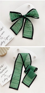 Close-up of a dark green polka dot chiffon neckerchief with black hem for styling