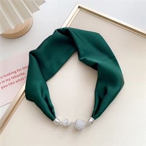 Detail of dark green satin scarf featuring magnetic rhinestone ball buckles and silver finish